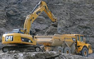 What Is Moly Grease? 6 Excavator loading a heavy tractor with gravel.