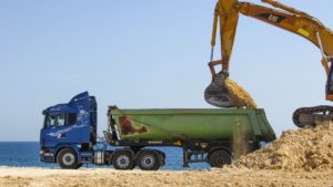 Excavator filling dump truck.