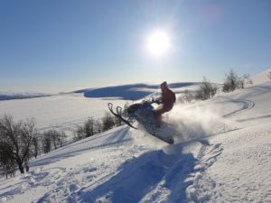 Synthetic Marine Wheel Bearing Grease 8 Snowmobile riding through mountains.