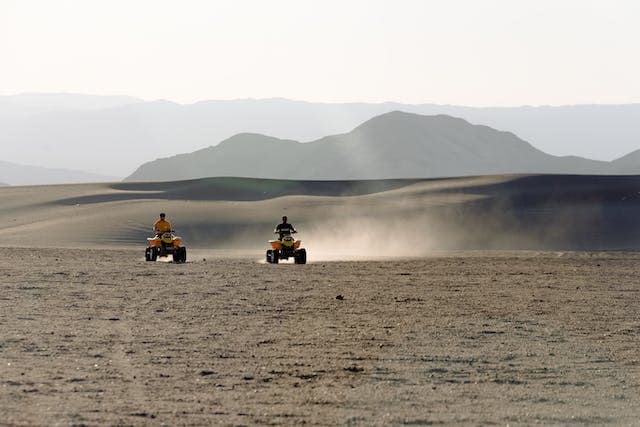 Featured image for "Best Oil for ATV with Wet Clutch" blog post. ATV racing through the desert.