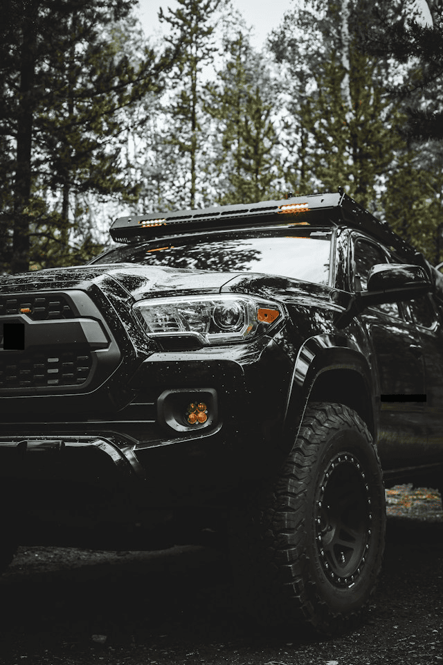 Featured image for "Unleash Adventure: Top 10 Best MPG 4 Wheel Drive Trucks for Your Outdoor Escapades" blog post. Black off-road vehicle.