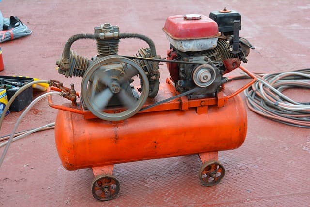 Featured image for "Unlocking Savings: How Full Synthetic Non Detergent Air Compressor Oil Cuts Down Your Maintenance Costs" blog post. Orange compressor.