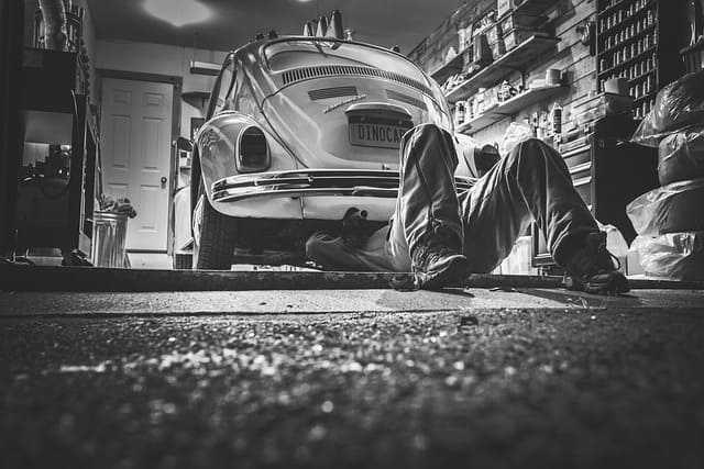 Featured image for "8 Automotive Maintenance Tips for Extending Vehicle Lifespan" blog post. Man fixing car.