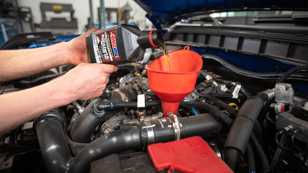 Featured image for "When to Change Engine Oil: Expert Answers to Common Questions" blog post. Adding motor oil.