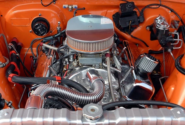 Featured image for "Understanding Engine Oil Pump Types: A Comprehensive Guide" blog post. Orange car engine.